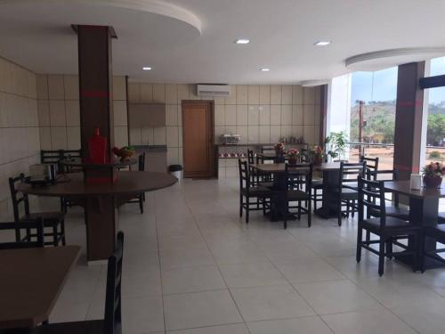 a dining room with tables and chairs in a restaurant at Gaivota Hotel in Eldorado dos Carajás