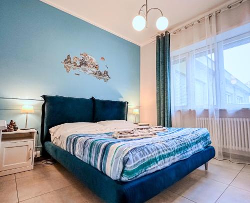 a bedroom with a bed with blue walls and a window at Velvet Suite - Garage Privato - Metro Dante in Turin