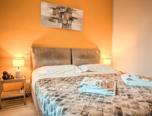 a bedroom with a bed with two towels on it at Velvet Suite - Garage Privato - Metro Dante in Turin