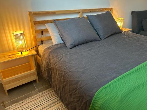 a bedroom with a bed with a lamp on a table at L'Agolum - B&B Baisy-Thy in Genappe