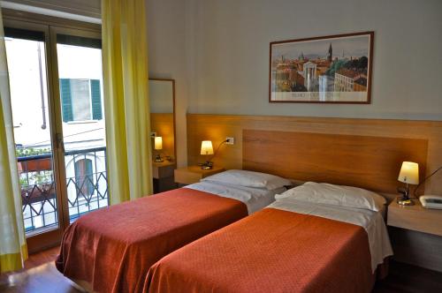 a hotel room with two beds and a balcony at Hotel Dover in Milan