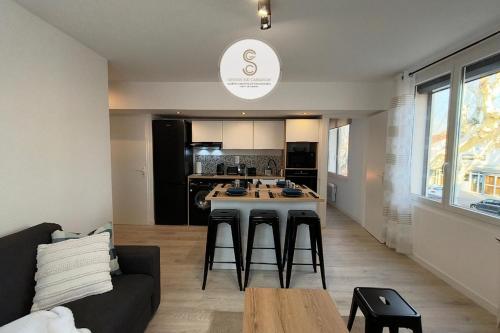 Stalingrad Arles Centre في آرل: غرفة معيشة مع أريكة ومطبخ