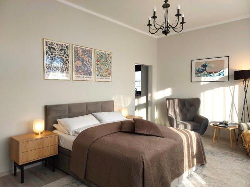 a bedroom with a bed and a chair at Tullu Apartament - w centrum, blisko bulwaru, blisko molo in Ostróda