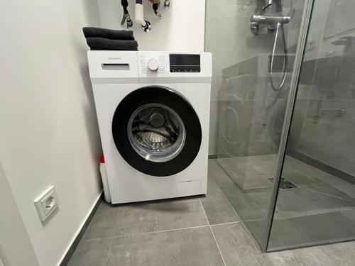 a washing machine in a bathroom with a shower at 2 Minunten neben kaiserlichem Park, Zentrumnähe in Vienna