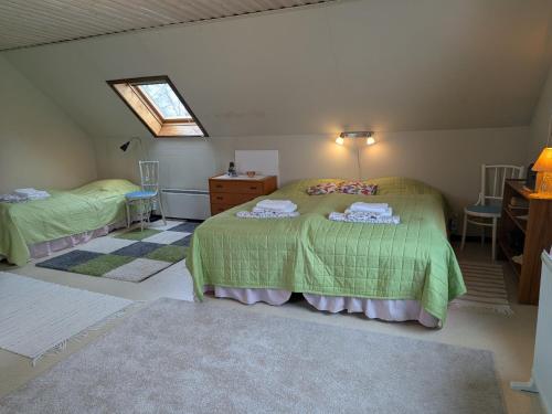 a bedroom with a green bed and a window at Vindslägenhet på Bjäre in Båstad