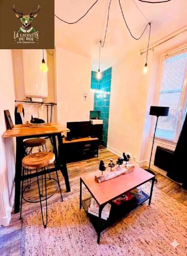 a living room with a table and a dining room at La Cachette du Roi in Fontainebleau