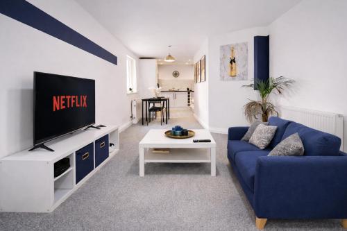 a living room with a blue couch and a tv at Poets Court in West Bromwich