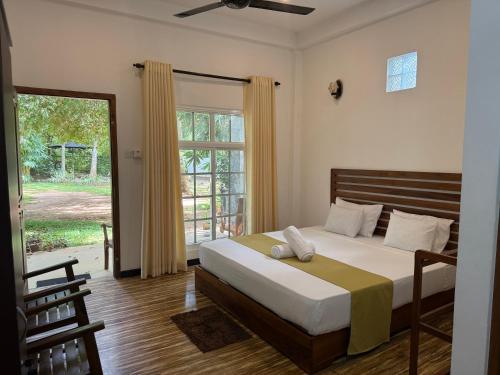 a bedroom with a bed and a large window at Imperial Resort in Udawalawe