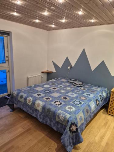 a bedroom with a bed with a blue comforter on it at Marias house i Agger in Vestervig