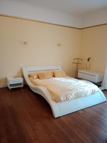 a bedroom with a large white bed and a wooden floor at Chambre d'hôtes au manoir proche mer in Gamaches
