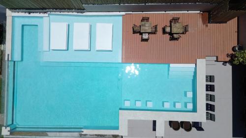 a building with a swimming pool next to a house at Chez Max Pousada in Morro de São Paulo