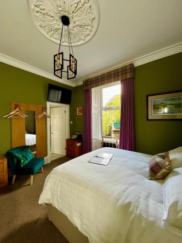 a bedroom with a large bed and a window at Ravenswood Guest House in Stirling