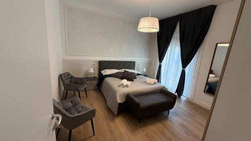 a bedroom with a bed and a chair and a mirror at La Divina Commedia in Florence