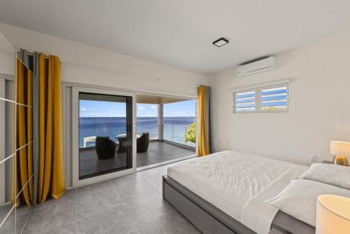 a bedroom with a bed and a view of the ocean at Lagun Ocean View Apartments & Studio in Lagun
