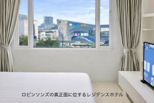 a bedroom with a window with a view of a city at The Sriracha Residence in Si Racha