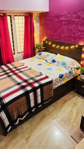 a large bed in a bedroom with a purple wall at Munnar Clubhouse in Anachal