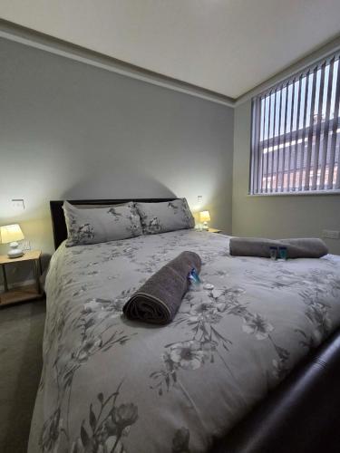 a bedroom with a bed with a blanket and a window at 159 Smart Apartments in Newark-on-Trent