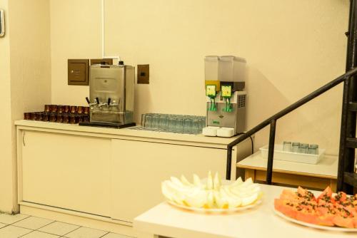 a kitchen with a counter with aasteryasteryasteryasteryasteryasteryasteryasteryastery at Hotel Piacenza in Caxias do Sul