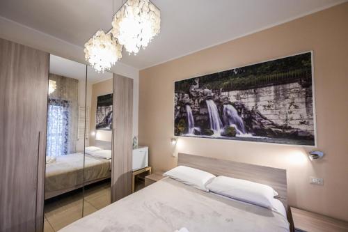 a bedroom with a bed and a waterfall painting on the wall at Le Fontane del Re in Caserta