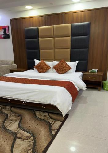 a bedroom with a large bed with a large headboard at هبوب الغيوم للشقق المخدومة - إقتصادي - Hobob Alghyoum For Serviced Apartments - Economy in Najran