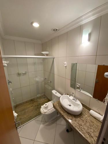 a bathroom with a sink and a toilet and a mirror at Imperial Cidade Smart Suítes in Ouro Preto