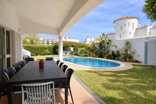 a patio with a table and chairs next to a pool at Solar - Private Pool - 12 Guests - Albufeira in Albufeira
