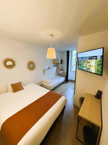 a bedroom with a large bed and a television at Contact Hôtel les Platanes - Clim Mobile en Option in Villeneuve-sur-Lot