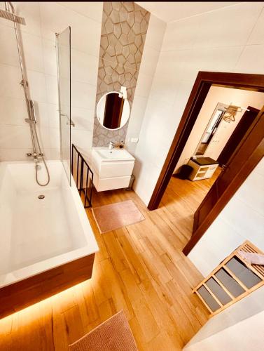 a bathroom with a tub and a sink at APARTAMENT RYBICAL nad jeziorem in Ryn