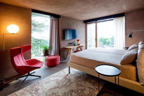 ein Schlafzimmer mit einem Bett, einem Stuhl und einem Fenster in der Unterkunft Muchele Boutique Hotel in Burgstall