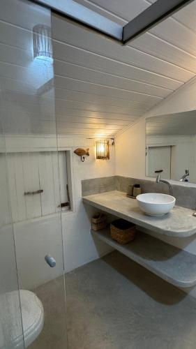 a bathroom with a sink and a mirror at Viva Vida Caraiva in Caraíva