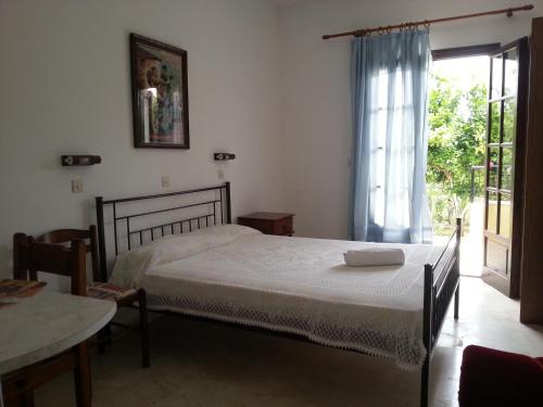 a bedroom with a bed and a table and a window at Villa Helen in Arillas