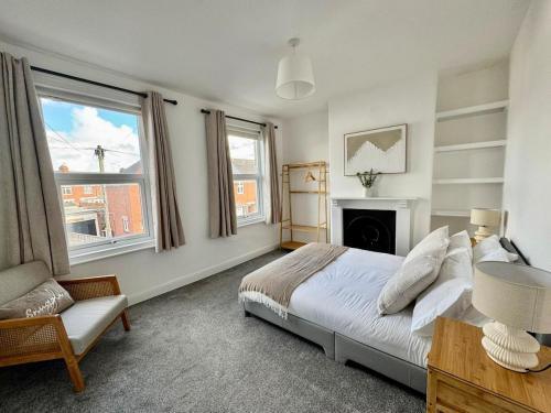 a bedroom with a bed and a chair and a fireplace at Stylish 2-Bed Home with Garden in Saint Thomas Station