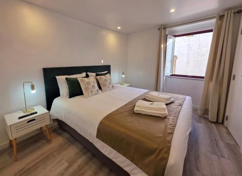 a bedroom with a large bed and a window at Aconchego da Vila in Castelo de Vide