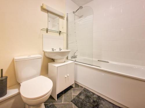 a bathroom with a toilet and a sink and a tub at The Beauchamp Modern 2BR Coventry City Centre Apt Free Parking in Coventry