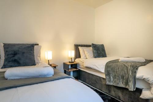 a room with two beds and two lamps in it at The Beauchamp Modern 2BR Coventry City Centre Apt Free Parking in Coventry