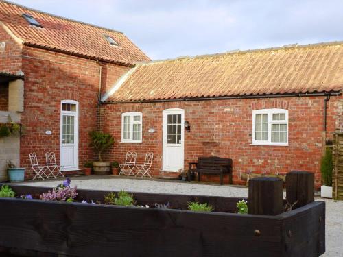 a brick house with a garden in front of it at Summertree Farm The Granary in Thornton Dale