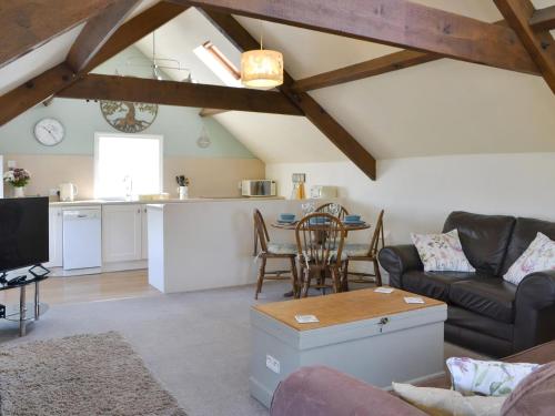 a living room with a couch and a table at Summertree Farm The Granary in Thornton Dale