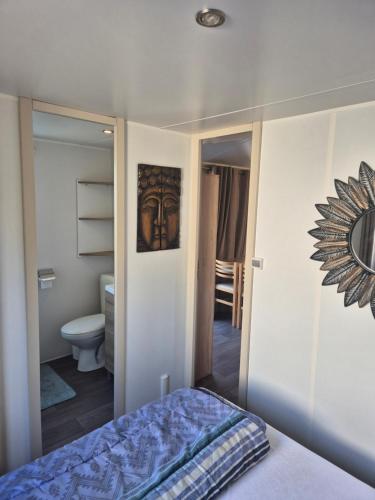 a bedroom with a bed and a toilet and a mirror at camping siblu le montourey fréjus in Fréjus