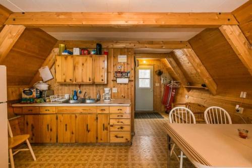 a kitchen with wooden cabinets and a table and chairs at The Papa Bear Cabin - Bear Creek Cabins in Winfield