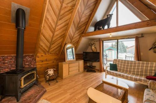 a living room with a fireplace and a cat sitting on the roof at The Papa Bear Cabin - Bear Creek Cabins in Winfield