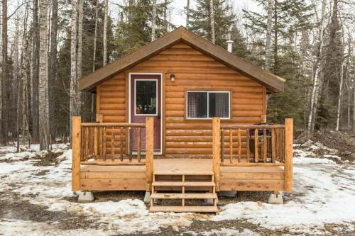 a cabin in the woods with snow on the ground at The Sheep Camp cabin- Bear Creek Cabins in Winfield