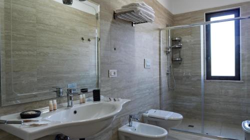a bathroom with a sink and a toilet and a shower at Kalispera Residence in Scalea