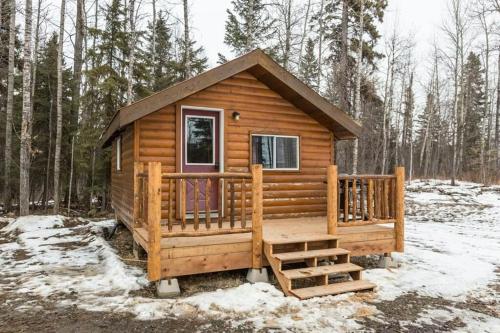 a wooden cabin in the woods in the snow at The Sheep Camp cabin- Bear Creek Cabins in Winfield