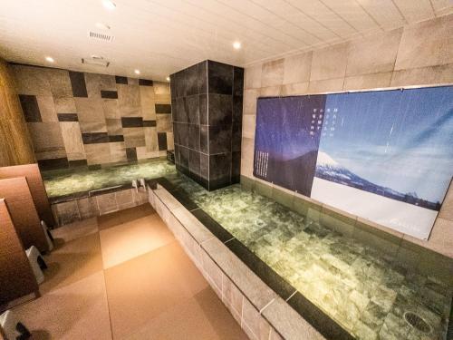 a large tub in a bathroom with a large window at HOTEL RELIEF Sapporo Susukino in Sapporo