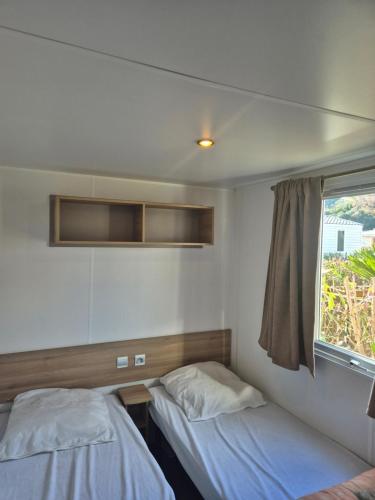 a bedroom with two beds and a window at camping siblu le montourey fréjus in Fréjus