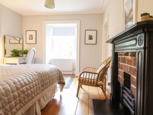 a bedroom with a bed and a fireplace at Bwthyn Mawr in Harlech