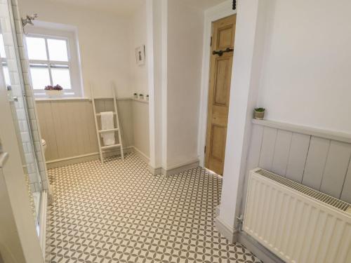 a hallway with a bathroom with a tile floor at Bwthyn Mawr in Harlech