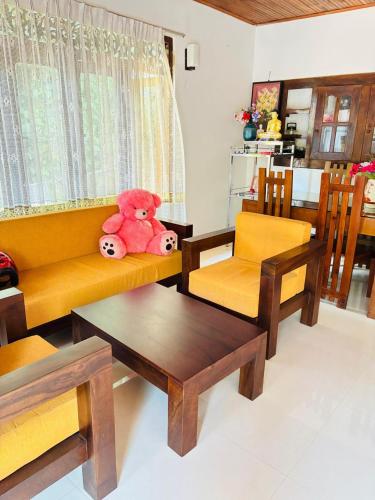 a living room with a teddy bear sitting on a couch at Nihal Villa in Weligama