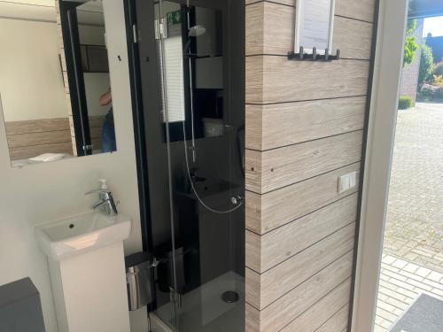 a shower with a glass door in a bathroom at Altes Gasthaus Stover in Löningen