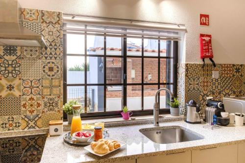 a kitchen counter with a sink and a window at Casa dos Andrades in Sesimbra